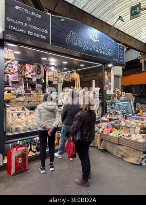 Reginella stall in Mercato Orientale, Genoa, Italy. Showing Italian salumi and cheese specialties purchased by customers. Stock Photo