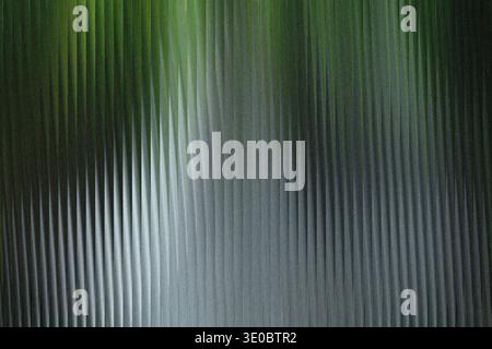 A textured abstract background with vertical ribbed patterns and a gradient from dark green to light gray Stock Photo