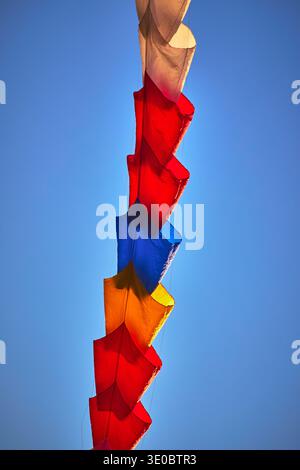 Colorful Kite Chain Against Blue Sky at Kite Festival Stock Photo