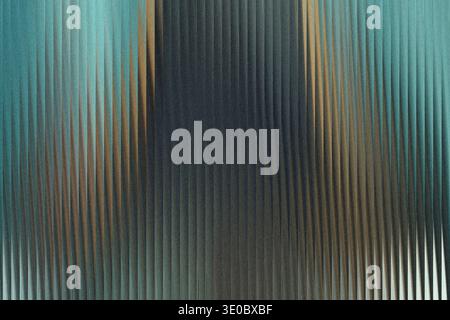 A textured glass surface with vertical ribbed patterns, displaying a gradient of cool blue and warm brown tones Stock Photo
