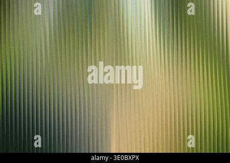 A textured background with vertical ribbed lines, featuring a gradient of green and yellow hues, creating a sense of depth and abstract pattern Stock Photo