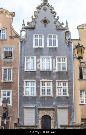 Gdansk, a city on the Baltic coast of northern Poland, Europe. Architectural facade of a tall building with gray walls and several white-framed window Stock Photo