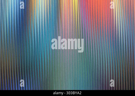 A vibrant abstract background features a textured surface with vertical lines in a gradient of blues, greens, reds, and yellows, creating a dynamic an Stock Photo