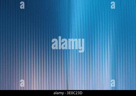 A closeup view of a textured blue surface with vertical ribbed lines and a soft gradient of light Stock Photo