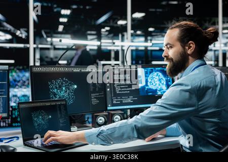 Computer scientist in data center optimizing hardware for AI tasks, increasing workloads. Server room IT professional automating system diagnostics using deep learning predictions Stock Photo
