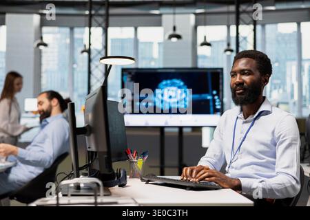 Engineer adjusting deep learning algorithms parameters at work to automate tasks. African american man in tech company working with AI driven insights for code optimization Stock Photo