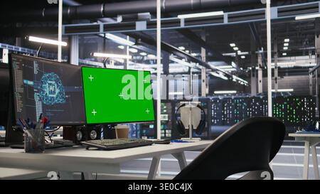 Green screen desktop PC set up in data center overseeing server infrastructure powering artificial intelligence workflows. Chroma key displays used for monitoring backend systems Stock Photo