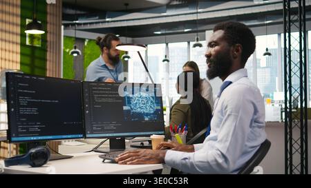 Computer scientist using AI on computer to optimize performance and forecast issues. African american worker in office training machine learning models using PC, camera A Stock Photo