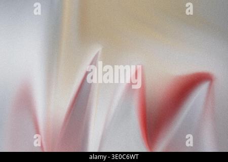 A softer abstract composition showing diffused red shapes blending into light grey and beige tones with a noticeable spray paint texture throughout th Stock Photo