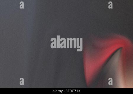 An abstract image dominated by a dark, heavily textured surface, possibly leather or rough material, featuring a sharp, bright red triangular shape em Stock Photo