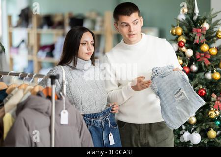 couple chooses jeans instead in a clothing store Stock Photo