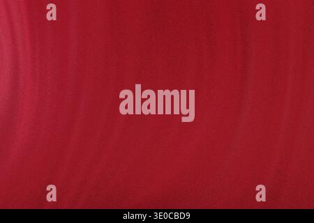 A close-up shot of a smooth, crimson red fabric showing subtle texture and slight vertical lines. The color is a deep, rich red. Stock Photo