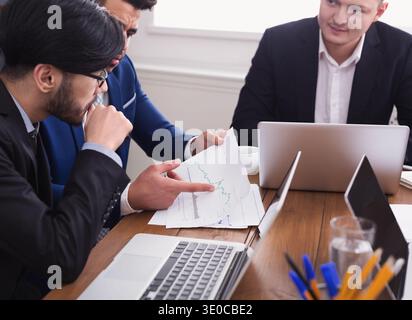 Business man and partners discussing documents in office Stock Photo