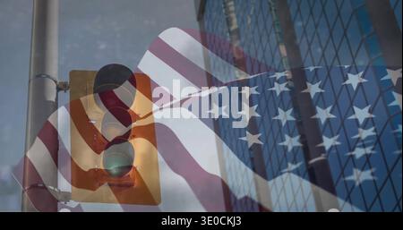 Sweeping US flag overlay stretching across downtown road, showing green signal and glass building Stock Photo