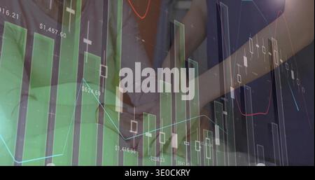 Analyzing two women using tablet in office, in dark jacket and light top, with chart overlay Stock Photo