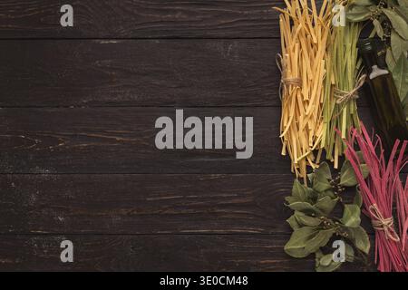 Mosaic Collection of Pasta Types and Herbs Arranged on Dark Wooden Surface in a Kitchen Setting Stock Photo