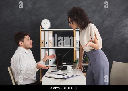 Couple of young colleagues arguing at office Stock Photo