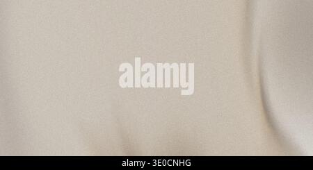 A close-up shot of a smooth, beige fabric with subtle draping creating soft folds and shadows. The texture is soft and the color is a muted beige. Stock Photo