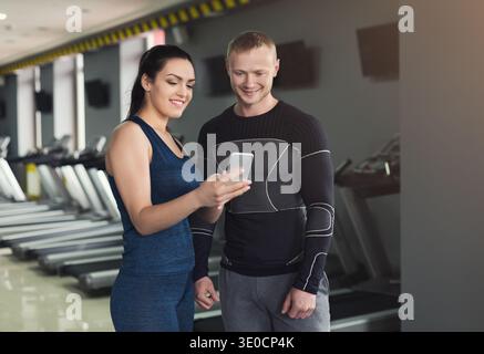 Young couple using smartphone in gym Stock Photo