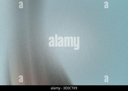 This image showcases a blurred abstract background with a gradient of soft blue and gray hues. The vertical blur creates a sense of depth and movement Stock Photo