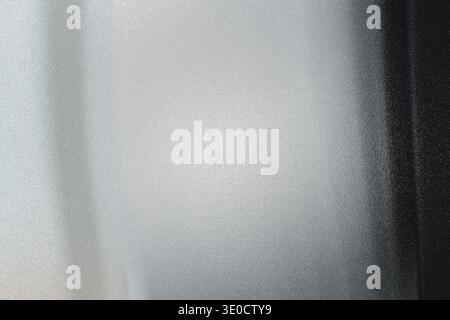 An out-of-focus image showing a gradient transition from light gray to dark gray and black. The blur creates a soft, indistinct texture. Stock Photo