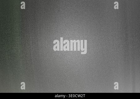 A blurry image showcasing a dark gray brushed metal texture with subtle variations in tone and a slightly lighter center. The overall effect is one of Stock Photo