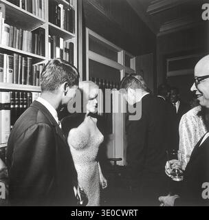 U.S. President John F. Kennedy (with his back to the camera), U.S. Attorney General Robert Kennedy (far left), and actress Marilyn Monroe, on the occasion of President Kennedy's 45th birthday celebrations at Madison Square Garden in New York City.  Arthur M. Schlesinger is at the far right.  Facing the camera in the rear is singer Harry Belafonte. Stock Photo