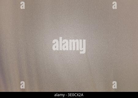 A blurry close-up shot reveals a light beige fabric with a subtle texture and a slight sheen. The image is softly lit, creating a muted and understate Stock Photo