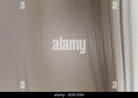 The image shows a section of a wall, appearing light beige or off-white. The texture is slightly uneven, suggesting a possible plaster or painted surf Stock Photo