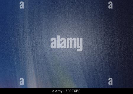An abstract image featuring a gradient of dark blue and gray tones. The texture is subtly mottled, creating a sense of depth and movement. The overall Stock Photo