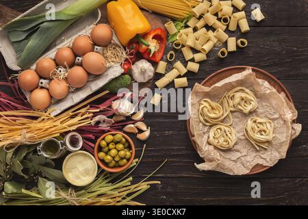 Cooking Ingredients Arranged in a Mosaic Style Showing Various Pasta, Vegetables, and Eggs Stock Photo