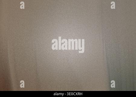 A slightly out-of-focus image showing a beige fabric texture. The image is predominantly a muted beige tone with subtle variations in shading. Stock Photo