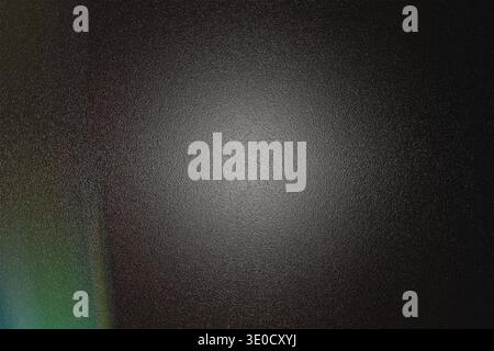 An abstract image featuring a dark, textured background with a brighter, glowing center. A subtle color gradient is visible along the left edge, addin Stock Photo