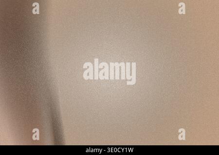 A slightly out-of-focus image showing a beige wall with a subtle gradient and texture. The lighting is uneven, creating a soft, muted effect. Stock Photo