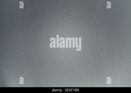 A close-up shot reveals a textured grey surface with subtle variations in lightness and a slightly uneven appearance. The overall tone is muted and mo Stock Photo