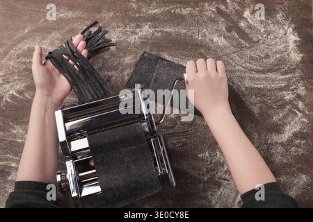 Preparing homemade fettuccine on pasta machine Stock Photo