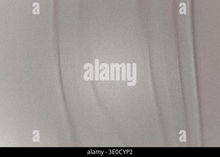 A detailed image showcasing the texture of a light gray fabric. The fabric shows subtle wrinkles and faint vertical lines, creating a slightly uneven Stock Photo