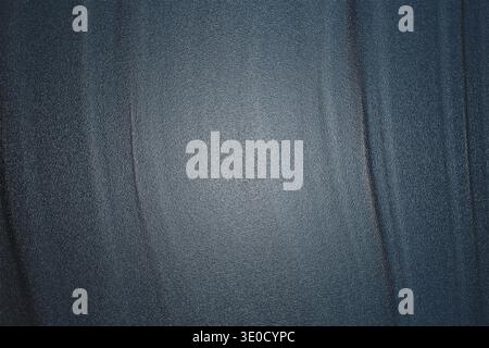 A close-up shot reveals a dark blue fabric texture featuring prominent vertical creases and a subtle gradient of light, creating a textured background Stock Photo