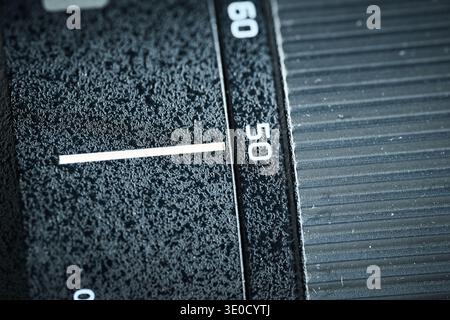 Detailed view of the focus ring and focal length markers on a professional black camera lens barrel Stock Photo