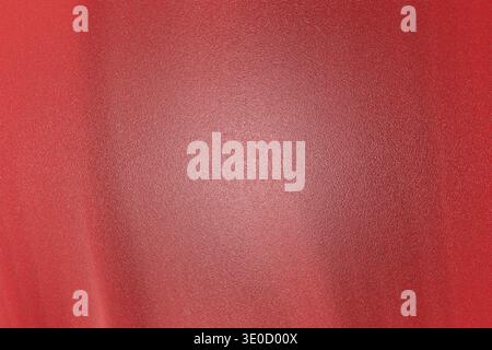 A close-up shot reveals a textured red fabric background with a subtle gradient effect. The color transitions from a deeper crimson to a lighter, pink Stock Photo
