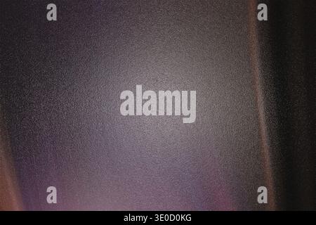 An out-of-focus image shows a dark gray or purplish surface with an indistinct texture. The lighting is low, creating a moody and somewhat mysterious Stock Photo