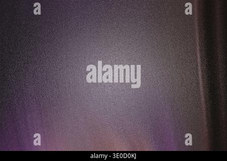 A blurry image showcasing a dark purple and gray textured background. The texture appears slightly grainy with subtle variations in shading and tone. Stock Photo