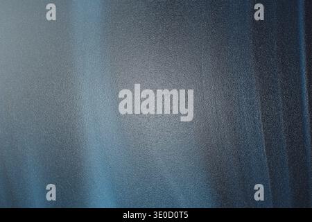 A blurry image featuring a gradient of dark blue and gray tones. The texture is smooth with subtle variations in shading, creating an abstract and moo Stock Photo