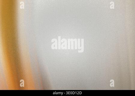 An out-of-focus image showcasing a vertical gradient transitioning from a warm gold tone to a cool gray. The effect creates a smooth, abstract backgro Stock Photo
