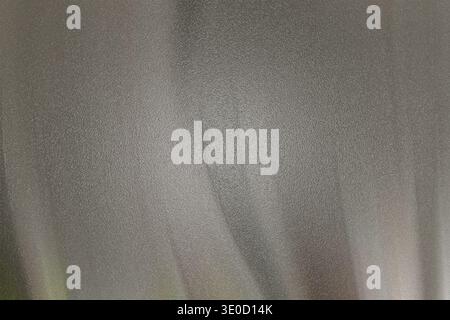 A detailed close-up shot reveals the subtle texture and draping of light grey fabric. The image emphasizes the soft folds and variations in tone. Stock Photo