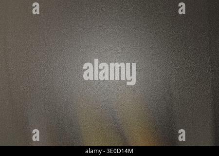 A close-up shot reveals a dark grey textured surface, possibly metallic or painted, with a subtle, diffused light source creating a slight highlight i Stock Photo