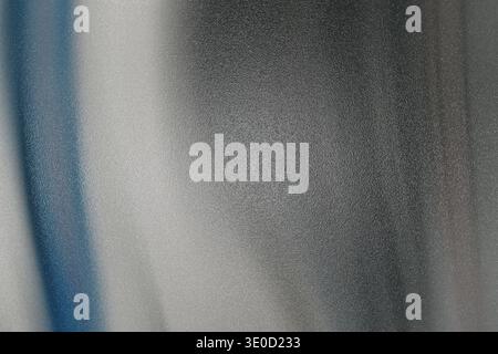 An image featuring a blurred, abstract background with vertical lines predominantly in shades of gray and a hint of blue. The texture appears smooth w Stock Photo
