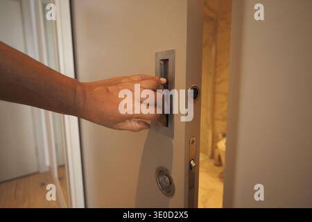 Hand presses doorbell button at home entrance Stock Photo