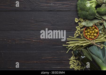 Green frame of pasta and vegetables on rustiv wooden background Stock Photo