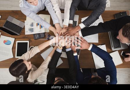 Team of united coworkers standing with hands together Stock Photo